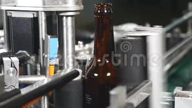 食品工业。 自动啤酒瓶生产线。 贴标签。 用于粘贴啤酒瓶标签的机器。 空空